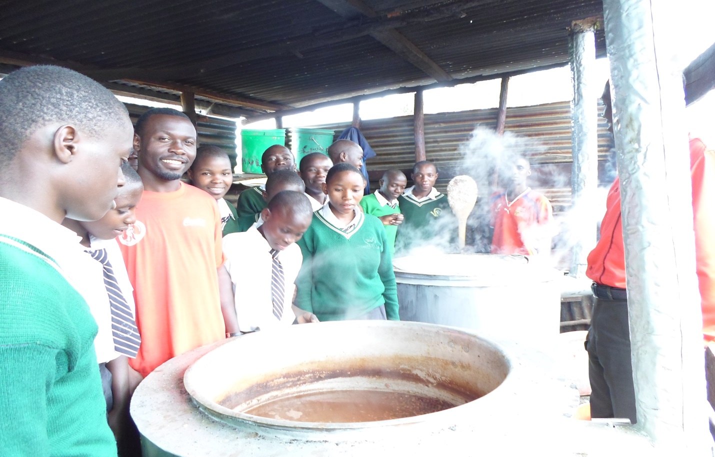 Teachers and Students being happy at the sight of Large Clean Cooking Stoves